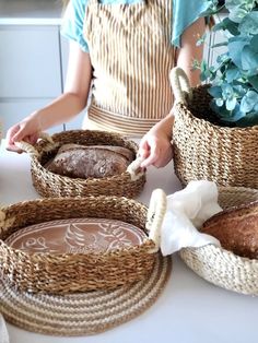 a woman is making bread in baskets on the table