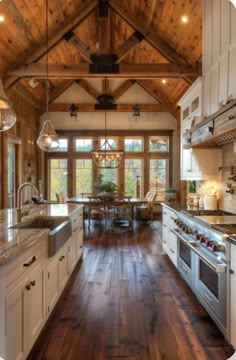 a large kitchen with wood floors and white cabinets, an island countertop and two ovens