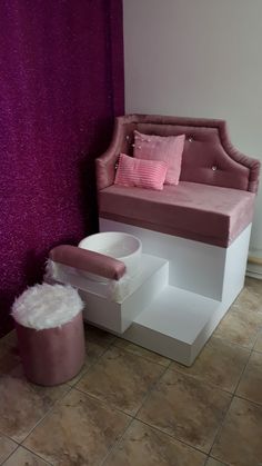 a pink and white couch sitting on top of a step next to a purple wall