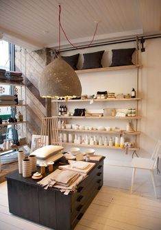 a room filled with lots of furniture and shelves next to a wall mounted light fixture