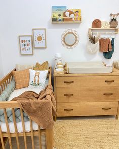 a baby's room with a crib, dresser and other items on the wall