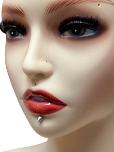 a mannequin's head with fake eyelashes and piercings on her nose