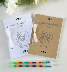 the wedding activity book and markers are next to each other with flowers in the background