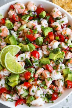 shrimp salad with avocado, tomatoes and cilantro in a white bowl