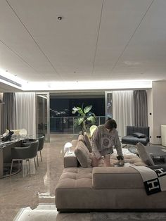 a man sitting on top of a couch next to a living room filled with furniture