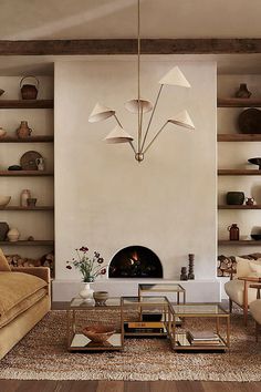 a living room filled with furniture and a fire place in front of a wall mounted fireplace