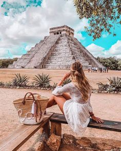 a woman sitting on top of a wooden bench