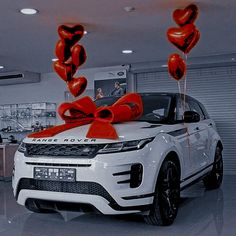 a white range rover with red heart balloons tied to it