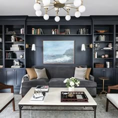 a living room filled with furniture and bookshelves next to a painting on the wall