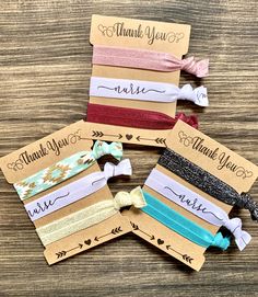 four small headbands with the words thank you written on them, sitting on top of a wooden table