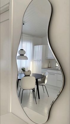 a mirror reflecting a dining room table and chairs