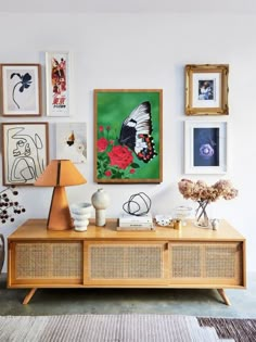 a living room with pictures on the wall and a wooden table in front of it