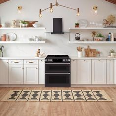 a kitchen with white cabinets and an oven in the center, along with open shelving