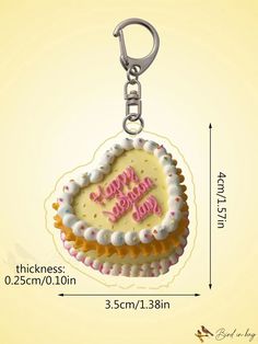 a cake shaped keychain with the words happy birthday written on it