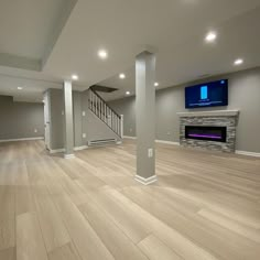 an empty living room with wood floors and a flat screen tv