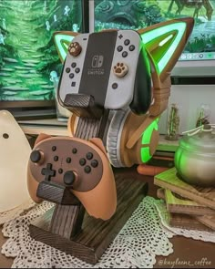 two video game controllers sitting on top of a wooden stand