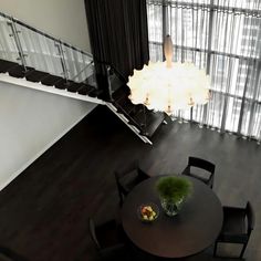 an overhead view of a dining room table with chairs and a chandelier hanging from the ceiling