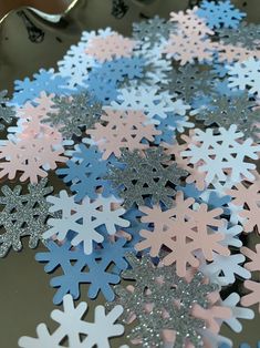 snowflakes are laying on a plate with silver glitter