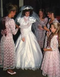 a group of women standing around each other in dresses