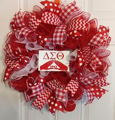 a red and white mesh wreath with the number 20 on it's front door