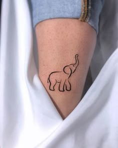 an elephant tattoo on the side of a woman's leg