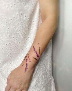 a woman's arm with purple flowers on it