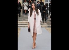 a woman in a white coat and pink dress