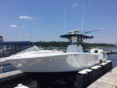 a white boat is docked at the dock