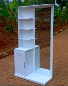 a tall white shelf with an open door