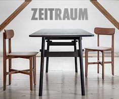 two wooden chairs and a table with the word zeitraum written on it