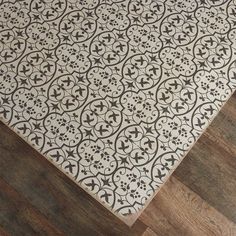 a white and black area rug on top of a wooden floor next to a wood floor