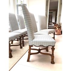 a set of four upholstered chairs in the middle of a room with a rug on the floor