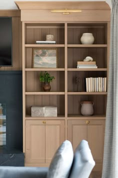 a living room filled with furniture and a flat screen tv on top of a wooden book shelf