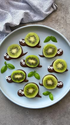 kiwi slices with googly eyes and leaves on a plate