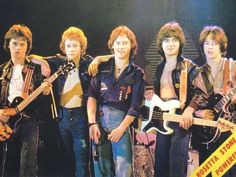 the group of young men are posing with their guitars