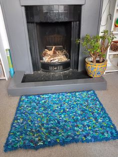 a living room with a fire place and rugs on the floor in front of it