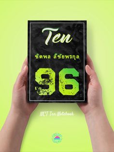 a person holding up a book with the number six on it's front cover