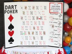 a table topped with cards and balloons next to a sign that says dart poker on it