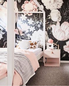 a bedroom with floral wallpaper and pink bedding