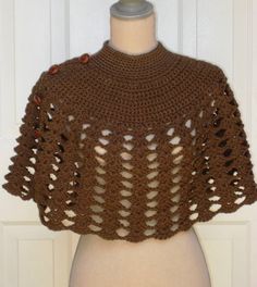 a brown crocheted shawl on top of a mannequin