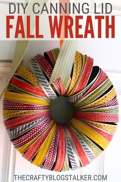 a colorful wreath hanging on the front door with text overlay that reads diy canning lid fall wreath