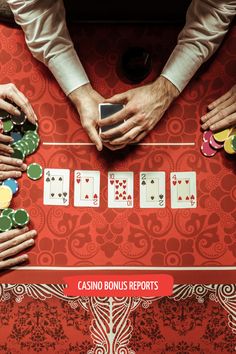 people playing cards on a red table with their hands over each other's chips