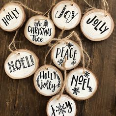 wooden ornaments with words on them are hanging from twine strings and tied to wood slices