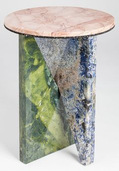 a marbled table with green and blue paint on the top, sitting in front of a white background