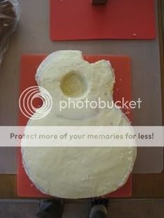 a person standing in front of a cake with an egg on it