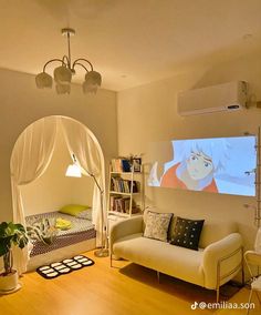 a living room with a couch, bookcases and a screen on the wall