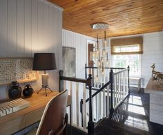 a living room with wooden floors and white walls, along with a staircase leading up to the second floor