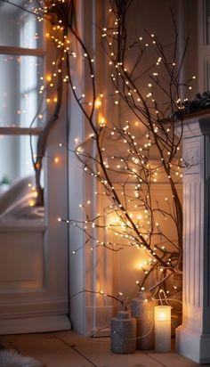 some candles are sitting on the floor near a tree with lights in front of it