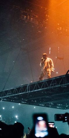 a man standing on top of a stage next to a crowd