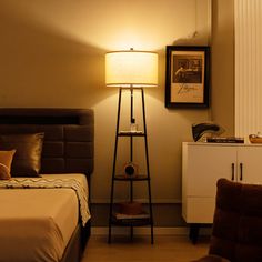 a bed sitting next to a lamp on top of a night stand in a bedroom